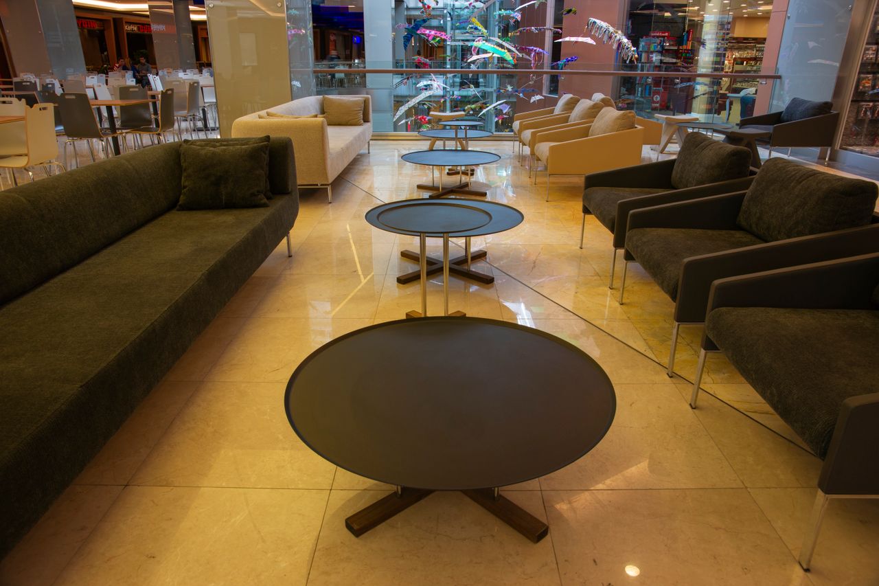 Contemporary lounge space featuring sleek sofas and round coffee tables in a shopping mall.